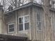 Rustic wood-sided home featuring various windows, surrounded by lush trees and natural landscape at 4401 E L G Rd, Efland, NC 27243