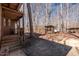 Charming exterior featuring wood siding, a covered porch, and outdoor structures nestled in a wooded area at 4401 E L G Rd, Efland, NC 27243