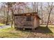 Rustic outdoor shed featuring wood siding and a weathered roof, blending seamlessly into the natural wooded surroundings at 4401 E L G Rd, Efland, NC 27243