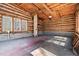 Interior log cabin garage with overhead lighting, windows and storage space set amidst wooden logs and a concrete floor at 4401 E L G Rd, Efland, NC 27243