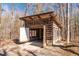 Exterior log cabin garage with open door, offers parking and storage space, set amidst a wooded backdrop at 4401 E L G Rd, Efland, NC 27243