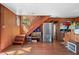 Rustic home interior with wooden stairs, a refrigerator, and a view into the adjacent kitchen area at 4401 E L G Rd, Efland, NC 27243