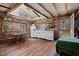 Rustic kitchen with log walls, wooden beams, vintage appliances, and a window view of the outdoors at 4401 E L G Rd, Efland, NC 27243