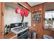 Rustic kitchen features red pots hanging above gas range, spice rack, and wood walls at 4401 E L G Rd, Efland, NC 27243