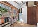Laundry room with a stacked washer and dryer and ample natural light from nearby windows and log cabin walls at 4401 E L G Rd, Efland, NC 27243