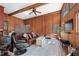 Cozy living room featuring wood paneling, a fireplace, and comfortable seating for relaxation at 4401 E L G Rd, Efland, NC 27243
