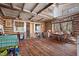 Rustic living room with log walls, hardwood floors, and exposed beams, offering a cozy, vintage ambiance at 4401 E L G Rd, Efland, NC 27243