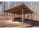 Rustic outdoor structure with a sturdy frame, perfect for storing equipment or providing sheltered space in the serene wooded setting at 4401 E L G Rd, Efland, NC 27243
