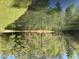 Scenic pond reflecting the surrounding lush trees, creating a serene and idyllic landscape at 4401 E L G Rd, Efland, NC 27243