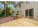 Backyard showcases a wooden deck, brick patio, sliding door and mature trees, ideal for enjoying the outdoors at 4508 Fox Rd, Raleigh, NC 27616