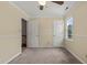 Simple bedroom with access to an additional room, window, and ceiling fan at 4508 Fox Rd, Raleigh, NC 27616