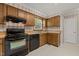 Well-lit kitchen featuring wooden cabinets, black appliances, and a window over the sink at 4508 Fox Rd, Raleigh, NC 27616