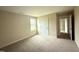 Neutral bedroom with large window, carpet, and white door at 47 Silver Ct, Smithfield, NC 27577