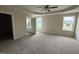 A spacious main bedroom with carpet, two windows, and a tray ceiling with a ceiling fan at 47 Silver Ct, Smithfield, NC 27577