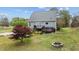 View of house with deck and landscaped backyard featuring a fire pit and lush lawn at 4810 Mitchell Mill Rd, Wake Forest, NC 27587