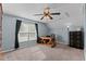 A well-lit room featuring a wooden desk with a chair, shelving and a ceiling fan at 4810 Mitchell Mill Rd, Wake Forest, NC 27587