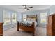 Bright bedroom featuring a wooden bed frame, ceiling fan, and windows offering scenic views at 4810 Mitchell Mill Rd, Wake Forest, NC 27587