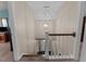 A staircase with carpeted steps and a classic white railing and a decorative chandelier above at 4810 Mitchell Mill Rd, Wake Forest, NC 27587
