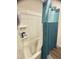 Standard bathroom features a shower-tub with blue shower curtain and convenient shelving at 50 Teal Dr, Youngsville, NC 27596