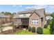 View of brick back exterior, screened deck with steps down to the yard and mature landscaping at 5317 Serather Ct, Garner, NC 27529
