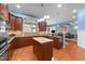 Well-lit kitchen with an island, wood cabinets, stainless appliances, and hardwood floors at 5317 Serather Ct, Garner, NC 27529