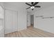 Bedroom with wood laminate flooring, ceiling fan, closet, and wood accent shelves at 5430 Crabtree Park Ct, Raleigh, NC 27612