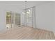Bright dining area with wood-look flooring, modern chandelier and sliding doors leading to an outdoor deck at 5430 Crabtree Park Ct, Raleigh, NC 27612