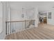 Bright entryway featuring a modern light fixture, wood and black iron railings, and attractive wood-look flooring at 5430 Crabtree Park Ct, Raleigh, NC 27612