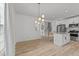 Open concept living area with wood-look floors, modern chandelier and seamless flow into the kitchen at 5430 Crabtree Park Ct, Raleigh, NC 27612