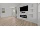 Cozy living room featuring a modern electric fireplace, a large flatscreen tv, and neutral decor with attractive wood flooring at 5430 Crabtree Park Ct, Raleigh, NC 27612