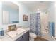 Well-lit bathroom with a modern vanity, framed mirror, and a tub/shower with a floral curtain at 5570 Normans Rd, Rougemont, NC 27572