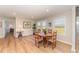 Bright dining area features hardwood floors, a round wooden table, and views of the backyard through large windows at 5570 Normans Rd, Rougemont, NC 27572
