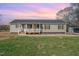 Charming single-story home with a covered front porch, green siding, black shutters, and well-maintained lawn at 5570 Normans Rd, Rougemont, NC 27572