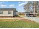 Well-maintained home exterior featuring a carport, landscaping, and gravel driveway at 5570 Normans Rd, Rougemont, NC 27572