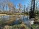 Scenic pond surrounded by trees offers a tranquil setting at 5570 Normans Rd, Rougemont, NC 27572