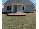 View of home's backyard featuring a partially covered patio area and spacious grassy lawn at 6320 Slopeside Ct, Raleigh, NC 27610