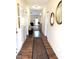 Inviting hallway with wood floors, decorative mirrors, and a glimpse into the cozy living room with fireplace at 6320 Slopeside Ct, Raleigh, NC 27610