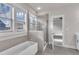 Bathroom featuring a glass enclosed shower and a soaking tub next to a bright window at 706 Fireball Ct, Knightdale, NC 27545