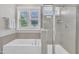 Luxurious bathroom with a soaking tub, separate glass-enclosed shower, and bright natural light at 706 Fireball Ct, Knightdale, NC 27545
