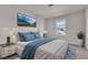 Bright bedroom with a plush bed, a mountain art, and a window with a partial view of the neighborhood at 706 Fireball Ct, Knightdale, NC 27545