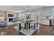Bright open-concept dining room showcasing a fireplace, modern light fixture, and access to the kitchen at 706 Fireball Ct, Knightdale, NC 27545