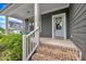 Charming front porch featuring brick steps, railing, gray siding and stylish front door at 706 Fireball Ct, Knightdale, NC 27545