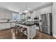 A spacious kitchen features an island, white cabinets, stainless steel appliances, and hardwood flooring, creating a modern culinary space at 706 Fireball Ct, Knightdale, NC 27545