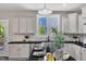 Bright kitchen features white cabinets, granite countertops, and a view to the backyard at 706 Fireball Ct, Knightdale, NC 27545