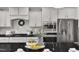 A kitchen with white cabinets, granite countertops, and stainless steel appliances, well-equipped for cooking and entertaining at 706 Fireball Ct, Knightdale, NC 27545