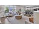 Bright open-concept living room with hardwood floors and large windows flows into the dining and kitchen areas at 706 Fireball Ct, Knightdale, NC 27545