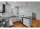 Well-lit kitchen with white cabinets, hardwood floors, and stainless steel appliances at 7201 Jonathan Dr, Wendell, NC 27591