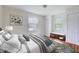 Bright bedroom with two windows, light walls, and hardwood floors at 829 Colleton Rd, Raleigh, NC 27610