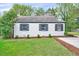 Well-maintained home exterior with a lush green lawn, manicured shrubbery, and freshly mulched flower beds at 829 Colleton Rd, Raleigh, NC 27610
