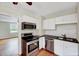 Well-lit kitchen features stainless appliances, white cabinetry, and hardwood flooring at 829 Colleton Rd, Raleigh, NC 27610